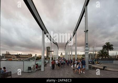 Menschen, die über die Rambla del Mar laufen - gewellter Holzsteg entlang des Port Vell in Barcelona, Spanien Stockfoto