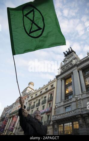 Madrid, Spanien. Januar 2020. Ein Protestler wagt während der Demonstration eine Extinction Rebellion Flag.Klimaschutzaktivisten vom Extinction Rebellion fordern australische Politiker dazu auf, mehr zu tun, um Bürger und Wildtiere vor der anhaltenden Buschfeuer-Krise zu schützen, und fordern Maßnahmen von Führern weltweit zur Verhinderung des Klimawandels. Kredit: Rafael Bastante/SOPA Images/ZUMA Wire/Alamy Live News Stockfoto