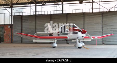 Ein kleines Flugzeug, im Hangarflugzeug auf einem Flughafen geparkt. Stockfoto