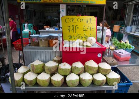 Kokosnüsse auf Eiskasten zum Verkauf im Straßenfood-Stall mit Preisschild Stockfoto