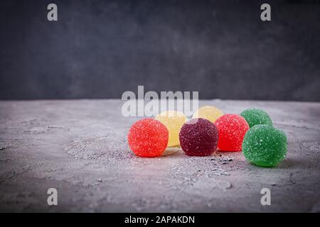 Bunte Marmelade auf grauem Hintergrund. Köstliche Jujube Bälle. Stockfoto