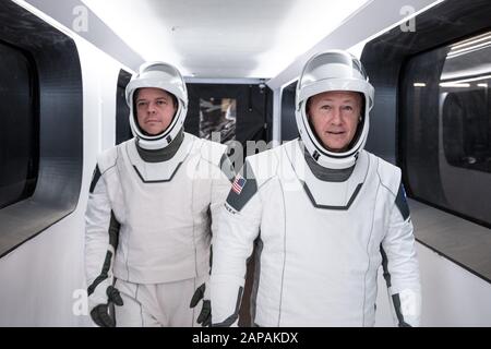 Die NASA-Astronauten Bob Behnken, Left, und Doug Hurley, die SpaceX spacesuits tragen, laufen während einer Generalprobe im Kennedy Space Center der NASA am 17. Januar 2020 durch den Crew Access Arm, der den Startturm mit dem Raumschiff SpaceX Crew Dragon verbindet. Ein Raumschiff SpaceX Falcon 9 und Crew Dragon steht auf dem Startplatz am Startkomplex 39A vor dem unbeaufenen In-Flight Abort Test des Unternehmens. Der Flugtest wird die Fluchtfähigkeiten des Raumschiffes in Vorbereitung auf gecrillte Flüge zur Internationalen Raumstation als Teil der kommerziellen Crew der Agentur Prog demonstrieren Stockfoto