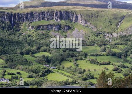 Kalkfelsen, Escarpments und Felsbrocken über grünen Feldern im ländlichen Irland an Den Dartry Mountains im County Sligo mit Glencar Lake Bottom. Stockfoto