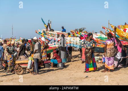 Bunte Kleider und Boote auf dem Fischmarkt in Tanji, Gambia, Westafrika bunte Kleidung und Boote auf dem Fischmarkt, Tanji, Gambia, Westafrika Stockfoto