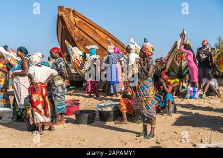 Bunte Kleider und Boote auf dem Fischmarkt in Tanji, Gambia, Westafrika bunte Kleidung und Boote auf dem Fischmarkt, Tanji, Gambia, Westafrika Stockfoto