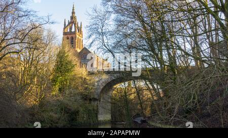 Von einem Park aus sehen Sie die Brücke über den Fluss Kelvin und die Kelvinbridge Parish Church Stockfoto