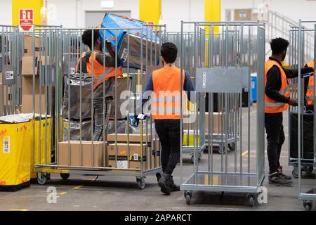 22. Januar 2020, Sachsen, Lampertswalde: Mitarbeiter von Amazon laden Pakete in verschiedene Karren in einem Vertriebszentrum. In der Halle werden Pakete der europäischen Logistikzentren des Online-Versandhauses ausgeladen, sortiert und an Kunden in der sächsischen Landeshauptstadt geliefert. Foto: Sebastian Kahnert / dpa-Zentralbild / dpa Stockfoto