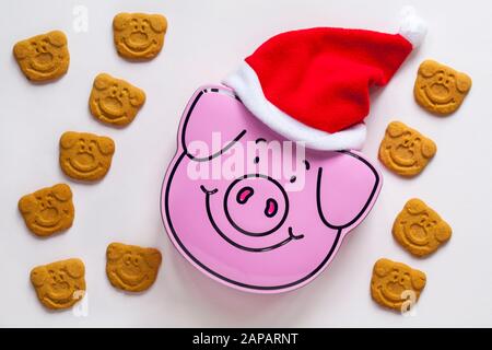 Percy Pigs Zinn von Keksen, die Santa Hut mit Percy Pig Keksen tragen, isoliert auf weißem Hintergrund Stockfoto