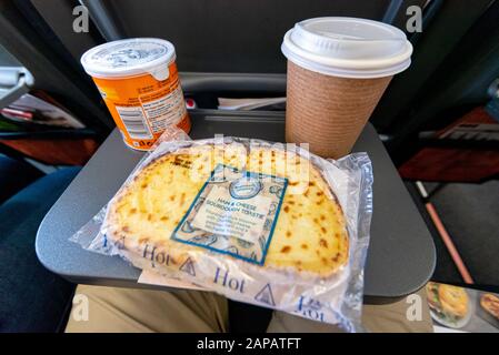 Essen und Trinken auf einem Tablett in einem easyJet Airbus A320 NEO Jet Flugzeug. Toastie mit Schinken und Käse, Pringles-Chips und Kaffee auf dem Flug Stockfoto