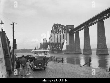 Schottland - Stadtbild Edinburgh Beschreibung: Autos am Ufer des Firth of Forth, mit Rechtsforth Bridge Anmerkung: Forth Bridge, eröffnet im Jahr 1890, ist eine Eisenbahnbrücke, die den Firth of Forth überspannt, das Wasser nördlich von Edinburgh Datum: August 1934 Standort: Edinburgh, Großbritannien, Schottland Schlüsselwörter: Brücken Stockfoto