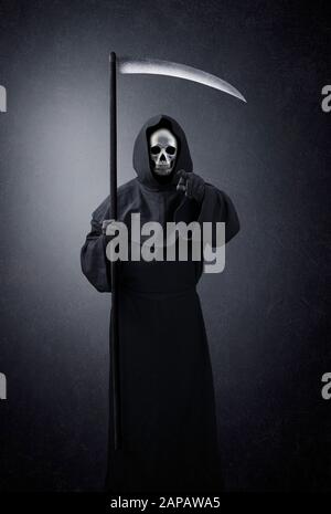 Grimmiger Reaper, der im Dunkeln auf dich zeigt Stockfoto