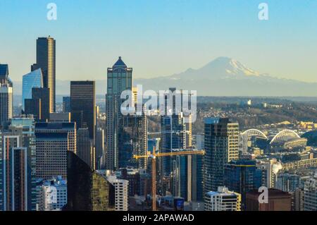 Die Wolkenkratzer der City of Seattle, Washington State an einem kalten Winterabend mit Mount Rainier in der Ferne Stockfoto
