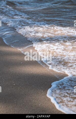 Hintergrund der Natur. Strandszene mit Meereswellen und Sand. Licht und Schatten Stockfoto