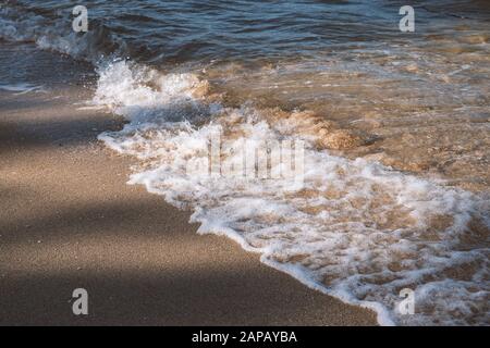 Hintergrund der Natur. Strandszene mit Meereswellen und Sand. Licht und Schatten Stockfoto