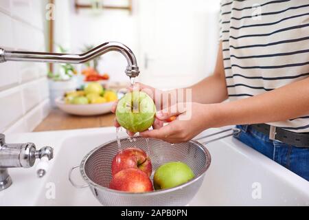 Frau, die frische, saisonale Äpfel waschen Stockfoto