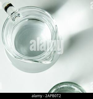 Reine klare Wasser in ein Glas Glas und Glas Krug steht auf einem weißen Hintergrund Stockfoto
