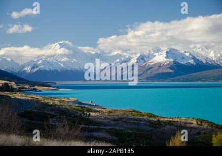 Schneebedeckter Mount Cook mit dem Pukaki-See im Vordergrund und blauem Himmel und weißen Wolken, South Island, Neuseeland Stockfoto