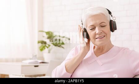 Entspannte Seniorin mit großartigem Klang des neuen Headsets Stockfoto