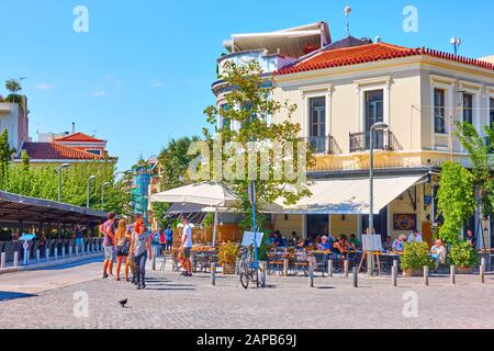 Athen, Griechenland - 21. September 2019: Straße mit Wanderern und Menschen, die an sonnigen Tagen im Freiluftcafé in Athen sitzen Stockfoto