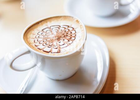 Heißen Cappuccino mit schönen Muster Schaum auf Tabelle Stockfoto