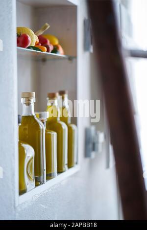Atmosphärische Stillleben Detail Nahaufnahme von einem Regal im Geschäft Einzelhandel verkaufen Wand in ländlichen Stil Land, Flaschen Öl Gemüse Zitrone Tomaten, verschwommen Stockfoto