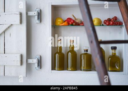 Detailreichtum aus einem Regal im Ladengeschäft Einzelhandel verkaufen Wand in ländlichem Stil, Flaschen Öl Gemüse Zitrone Tomaten, verschwommene diffuse Leiter Stockfoto
