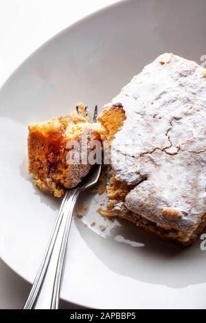 Apfelkuchen (Pita) aus einer Tasche, die in der Bäckerei gekauft wurde, und ein Stück mit Gabel.Studio auf weißem Hintergrund ansetzen Stockfoto
