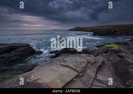 Moody Skies an den felsigen Ufern der Boobys Bay Cornwall Uk Stockfoto