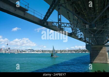 Blick über den Waitemata Harbour in der Innenstadt von Auckland von der North Shore mit der Unterseite der Harbour Bridge im Vordergrund. Neuseeland. Stockfoto