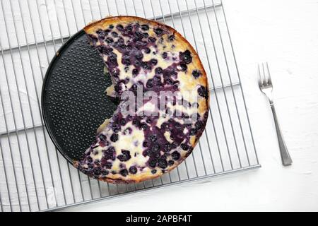 Hausgemachter Kuchen aus Blaubeere auf weißem Hintergrund und Blick auf den Metallboden mit Kopienbereich. Nahaufnahme von köstlichem frischen warmen Kuchen. Pastete aus frisch Stockfoto