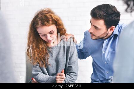 Fürsorglicher Ehemann tröstet seine depressive Frau bei einem Treffen mit dem Heiratsberater Stockfoto