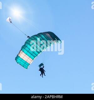 Start mit Tandem-Fallschirm in blauem Himmel Stockfoto