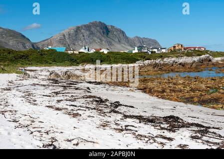 Betty's Bay, Westkappo, Südafrika. Dezember 2019. Berge, Immobilien und der Strand an der Betty's Bay auf der Gartenroute in Südafrika. Stockfoto