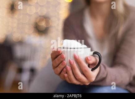 Frau wärmer Hände mit Kakaobecher mit Marshmallows Stockfoto