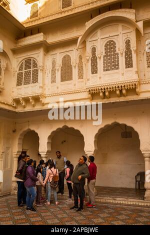 Indien, Rajasthan, Shekhawati, Bikaner, Stadtzentrum, Junagarh Fort, Gruppe indischer Touristen im Innenhof unterhalb des fein geschnitzten Jarokha-Balkons mit zenz Stockfoto