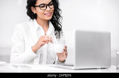 Mexikanisches Mädchen, das eine Tasse Mitgeld im Büro hält Stockfoto