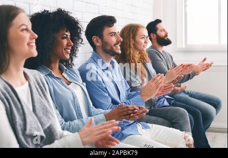 Multiethnische Gruppe von Menschen, die bei Treffen oder Seminaren applaudieren, die Hände klatschen Stockfoto