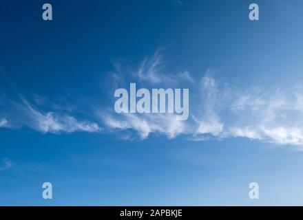 Weiße flauschige Cirrus- und Cirrocumulus-Wolken im tiefblauen azurblauen Himmel. Sommer gutes Wetter Konzept Hintergrund. Stockfoto