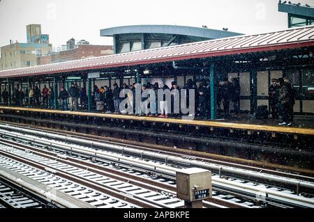 Reisende warten am Samstag, 18. Januar 2020, im Schnee an der 74. Street Station der Flushing Line im Stadtteil Jackson Heights in Queens in New York. In der Nachbarschaft von Jackson Heights befindet sich ein Mosaik ethnischer Gruppen, darunter Hispanics, Indianer, Pakistaner, Tibeter, Südostasier sowie langjährige jüdische und italienische Einwohner. (© Richard B. Levine) Stockfoto