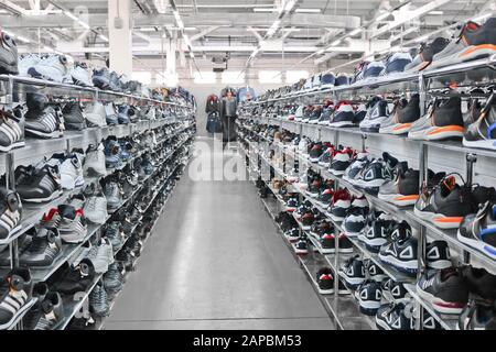 Sport-Sneaker für Herren stehen in einem Bekleidungs- und Schuhgeschäft auf Regalen. Stockfoto