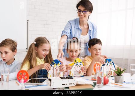 Schüler bauen moderne Roboter mit Hilfe des Lehrers Stockfoto