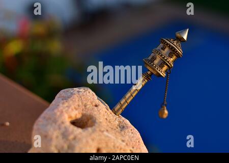 Tibetisches Gebetstrad am Abend Licht auf blauem Hintergrund Stockfoto