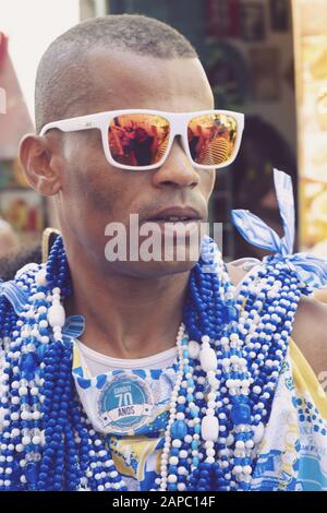 Ein Mann, der 2019 in der Uniform des Blocks Filhos de Gandhy (sic) beim Karneval in Salvador, Bahia, Brasilien gekleidet war Stockfoto