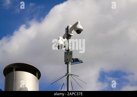 Niedrige Sicht auf Überwachungskameras gegen blauen Himmel und Wolken im Stadtzentrum von Venlo für mehr Sicherheit Stockfoto