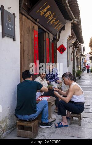 Einheimische spielen Karten in einer alten Stadtstraße in China Stockfoto