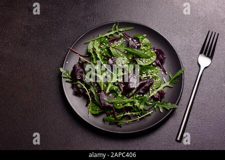 Gesundes Essen, Salatmischung mit Arugula, Spinat, Bullenblut, Rübenblättern und Mikrogrüns. Lebensmittelhintergrund, Kopierbereich Stockfoto