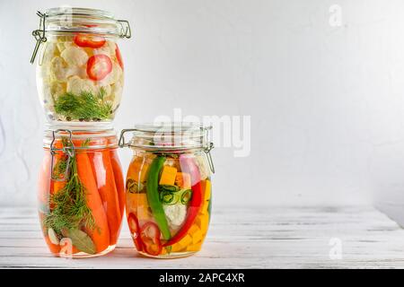 Drei Gläser von fermentierten Blumenkohl, Karotten, Gemüse auf einem hellen Hintergrund. Gärung ist eine Quelle von Probiotika. Stockfoto