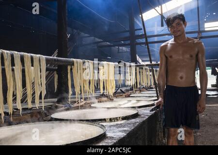 Ein Arbeiter, der essbares Reispapier mit dem in Schüsseln erhitzten Pith aus Reis, Koh Dach (Seideninsel), Phnom Penh, Kambodscha, zubereitet Stockfoto