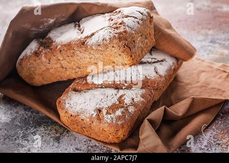 Schließen Sie frisch gebackenes Sauerteigsbrot mit Sonnenblumen und Kürbissamen an einer braunen Serviette. Stockfoto