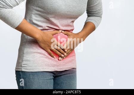 Beschnitten von schwarzen Frauen mit Menstruationsschmerzen im Bauchbereich Stockfoto